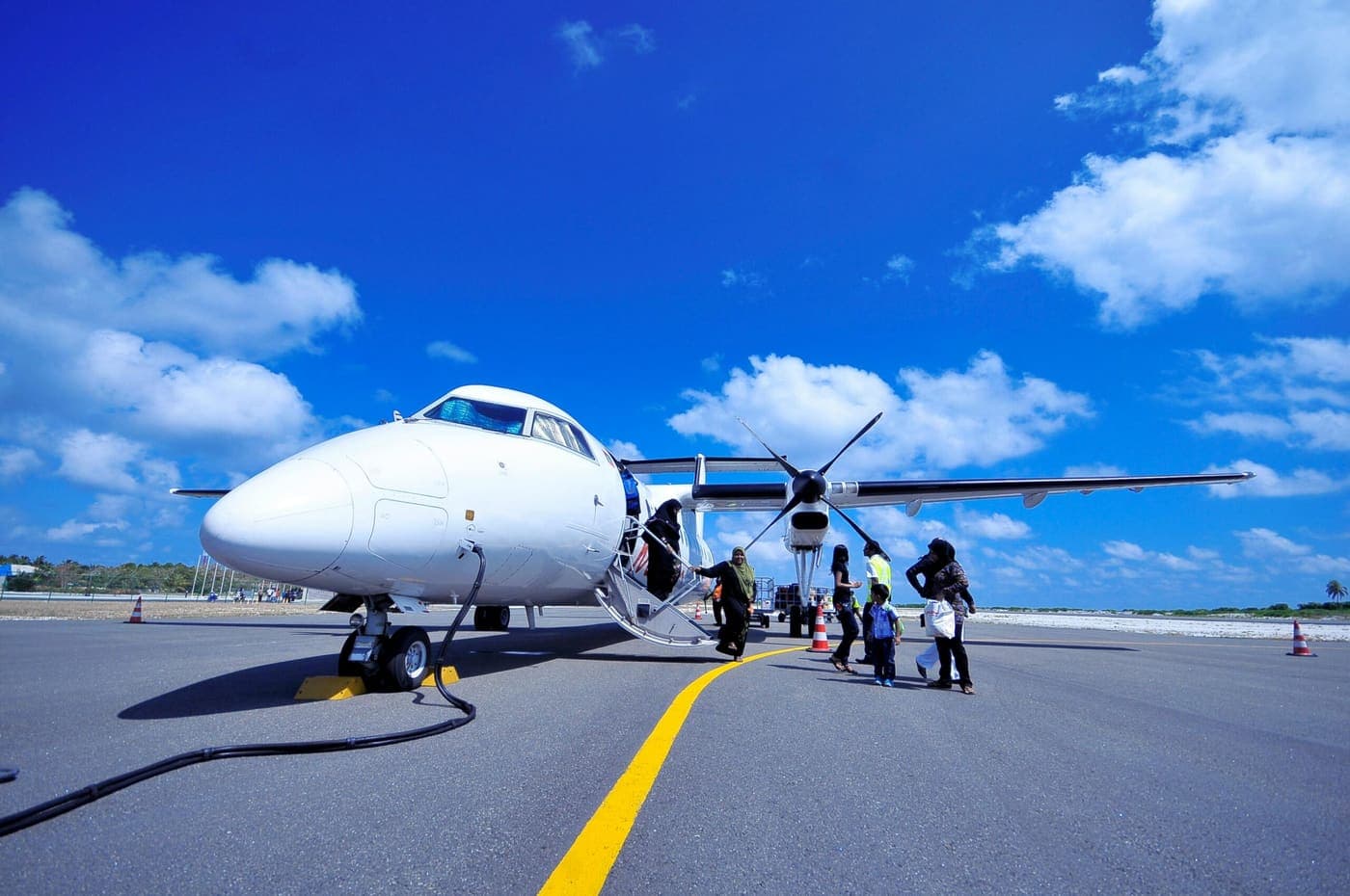 Passengers walking out to board a turboprop from the apron