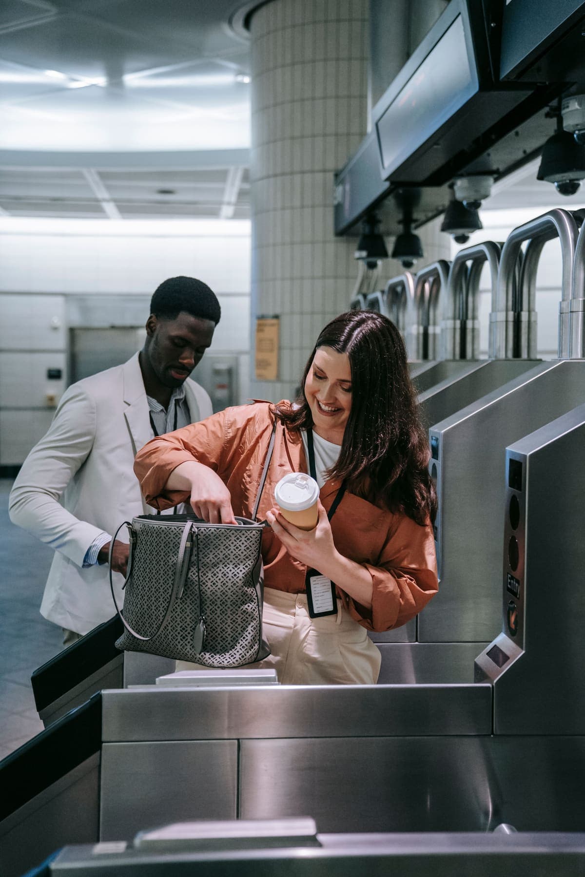 Two business travellers carrying visitor lanyards passing through airport gates